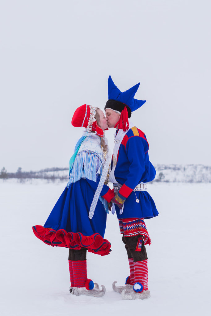 Samisk brudepar i Karasjok om vinteren kysser.
